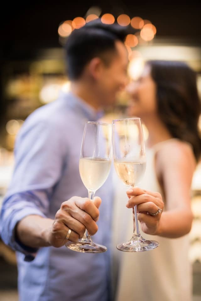 Deux personnes sourient en tentant une coupe de champagne