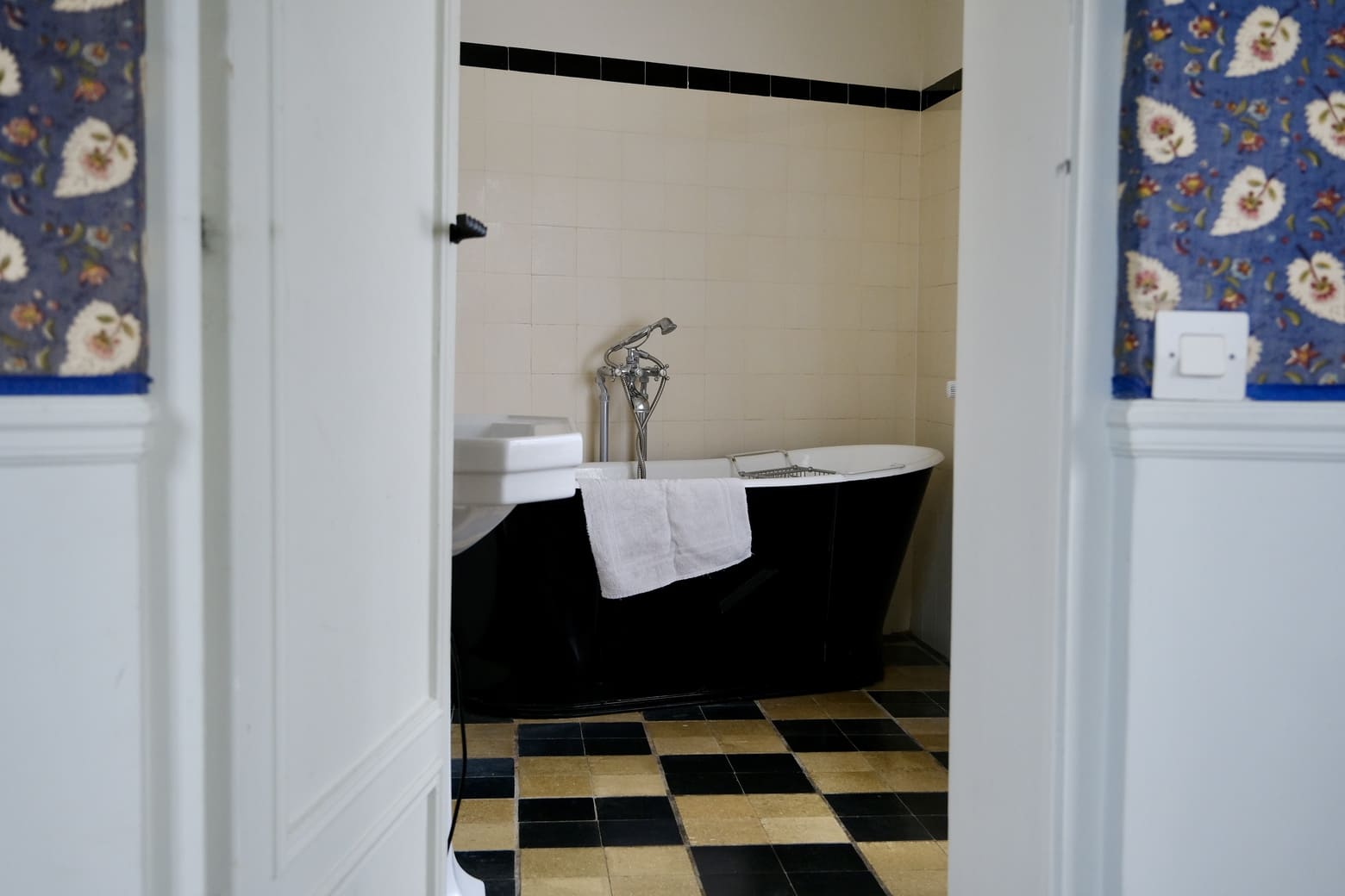 Vue sur une salle de bains avec carrelage blanc et noir.