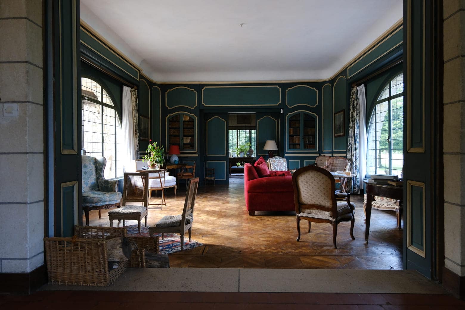 Vue sur un salon élégant avec fenêtres donnant sur le jardin.